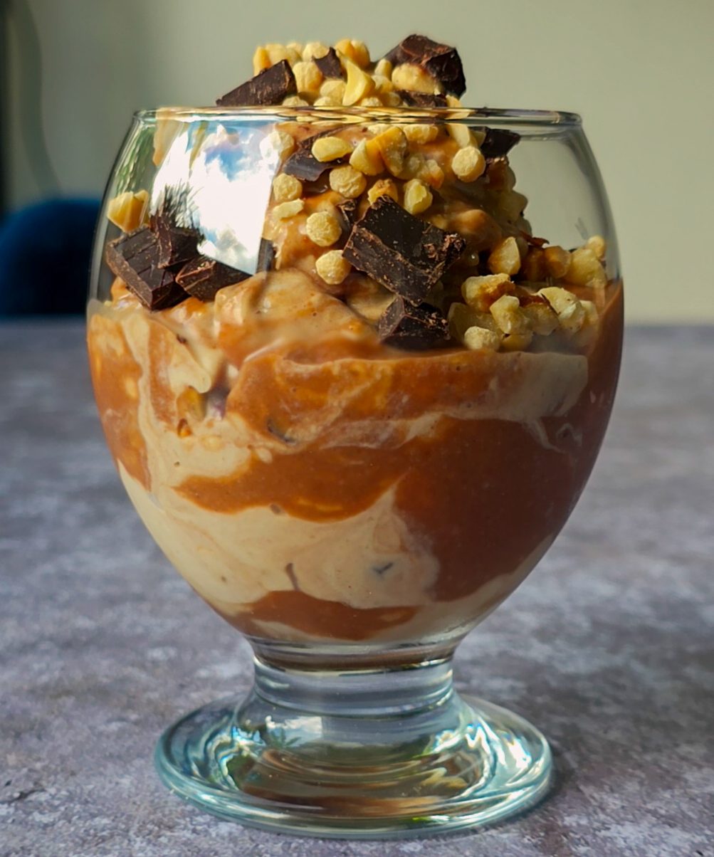 Cremiges Haselnuss-Vanille-Eis mit Dattelkaramell getoppt mit Haselnüssen, Zartbitterschokolade und Sojacrispies.