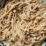 Spaghetti in einer Pfanne vermischt mit einer cremigen hellen Soße und kleinen Tofuwürfeln