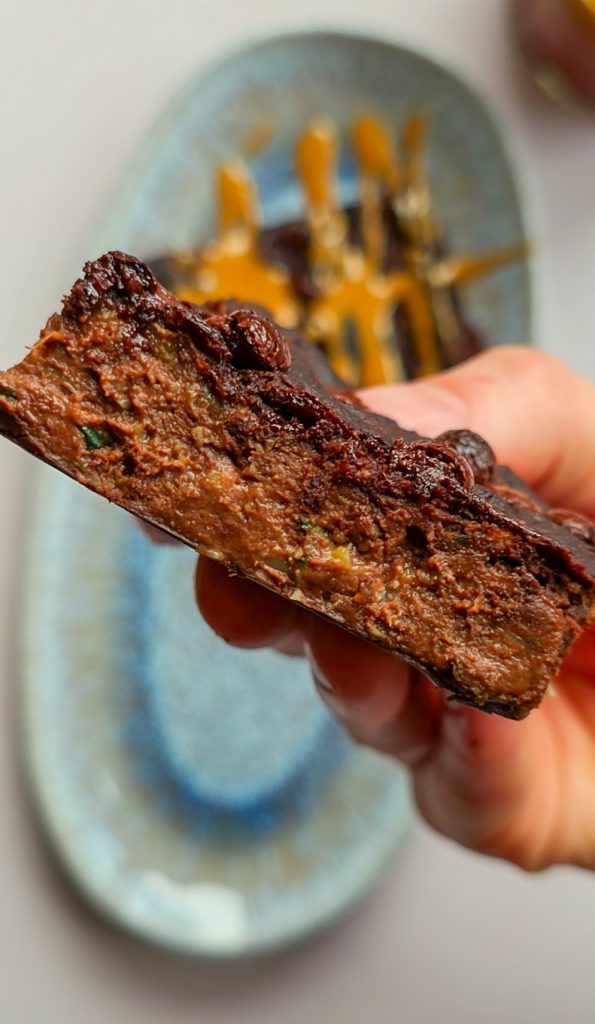 Querschnitt eines veganen Zucchini-Brownies – saftig, schokoladig und voller pflanzlicher Proteine.